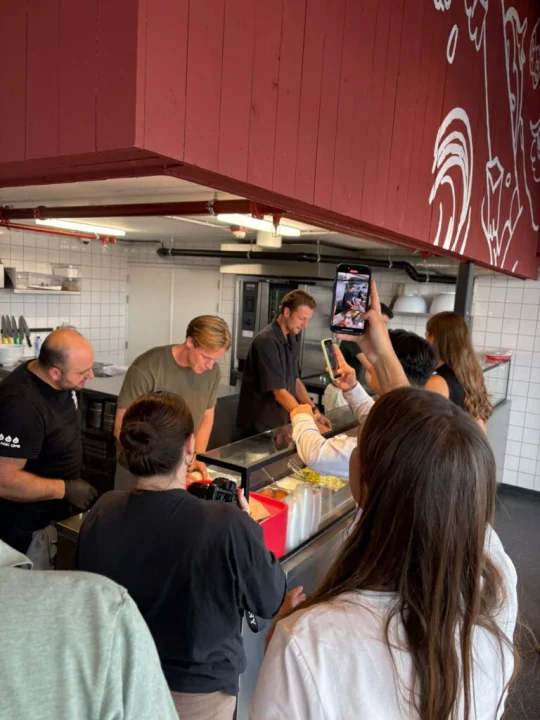 Food influencers and media guests rolling burritos during a Salsa Shop cooking workshop at Amsterdam Central, guided by our chef Alex.