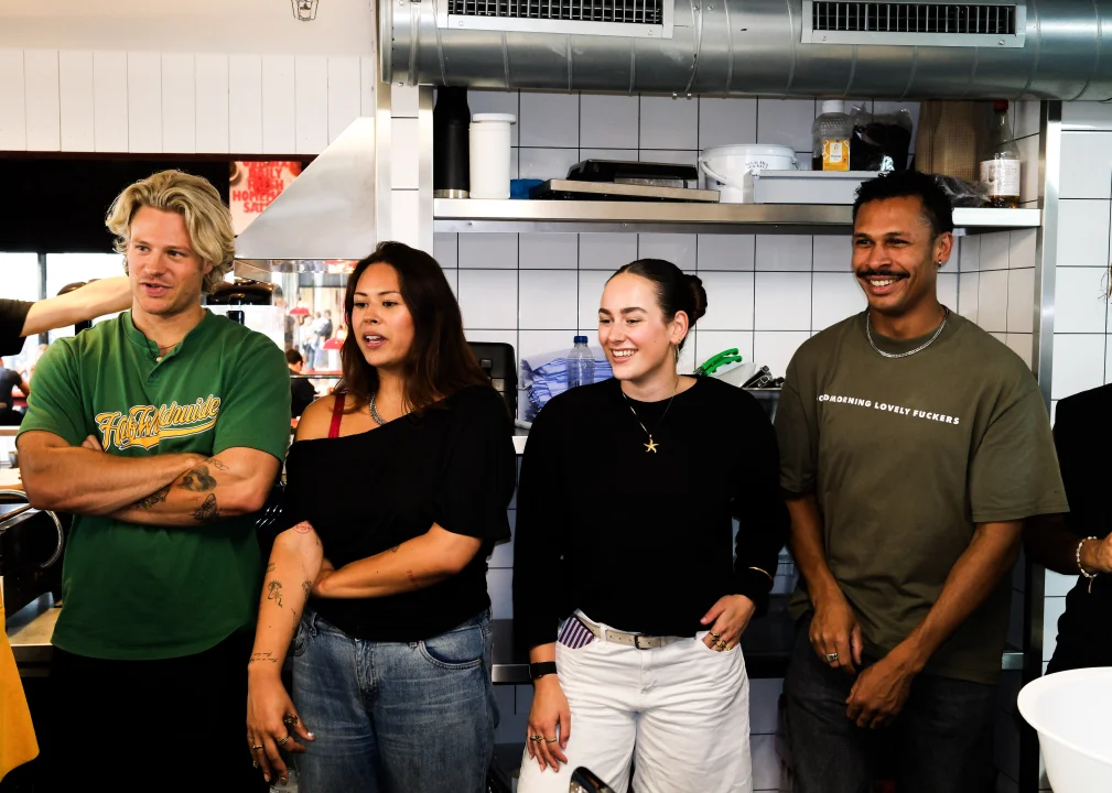Guests taking part in a Salsa Shop cooking workshop, learning about fresh ingredients and burrito making inside the Salsa Shop kitchen.